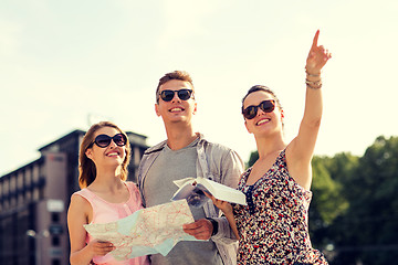 Image showing smiling friends with map and city guide outdoors