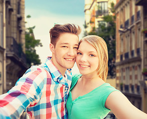 Image showing smiling couple with smartphone in city background