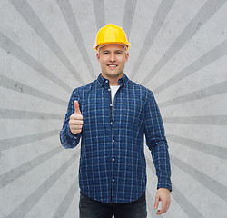 Image showing smiling male builder in helmet showing thumbs up