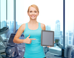 Image showing smiling sporty woman showing tablet pc in gym