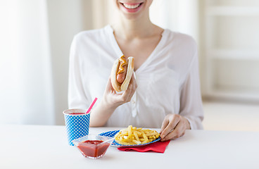 Image showing close up of woman eating hotdog and french fries