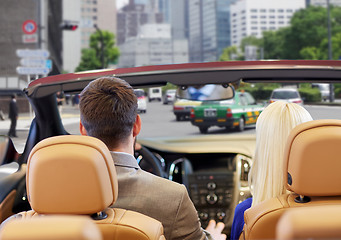 Image showing couple driving in cabriolet car over city street