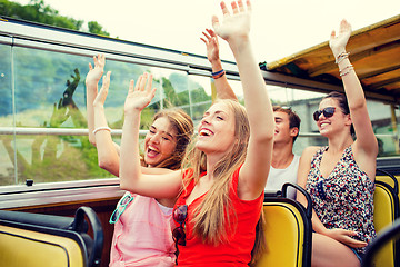 Image showing group of smiling friends traveling by tour bus