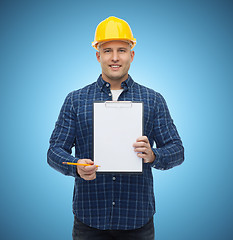 Image showing smiling male builder in helmet with clipboard