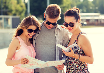 Image showing smiling friends with map and city guide outdoors