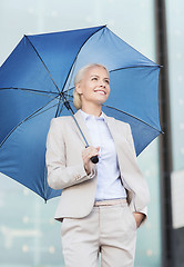 Image showing young smiling businesswoman with umbrella outdoors