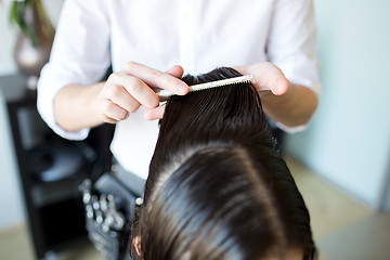 Image showing male stylist hands combing wet hair at salon