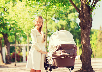 Image showing happy mother with stroller in park