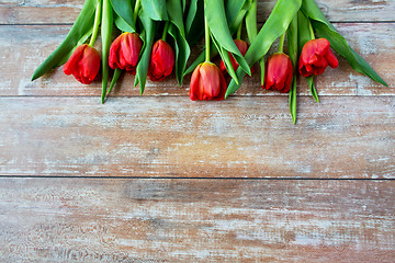 Image showing close up of red tulips on wooden background