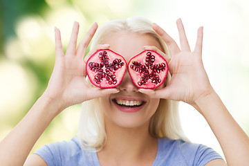 Image showing happy woman covering eyes with pomegranate