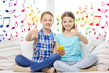 Image showing happy girls with smartphone sitting on sofa