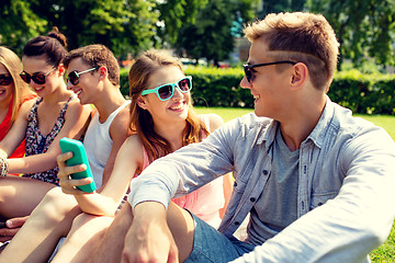 Image showing smiling friends with smartphone making selfie