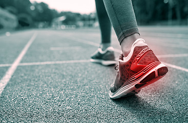 Image showing close up of feet with red spot running on track