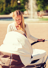 Image showing happy mother with stroller in park