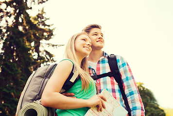 Image showing smiling couple with map and backpack in nature