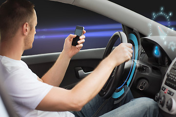 Image showing man looking to smart phone while driving car