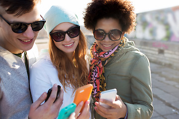 Image showing smiling friends with smartphones