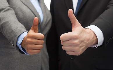 Image showing businessman and businesswoman showing thumbs up