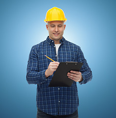 Image showing smiling male builder in helmet with clipboard