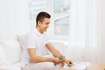 Image showing man with papers and calculator at home