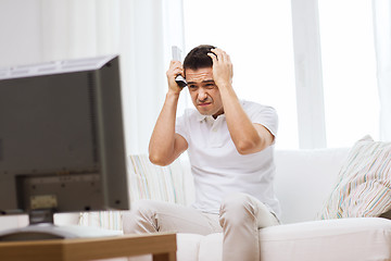 Image showing disappointed man watching tv at home