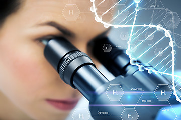 Image showing close up of scientist looking to microscope in lab