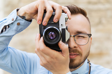 Image showing young hipster man with film camera in city