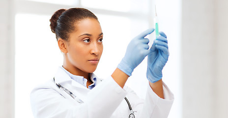 Image showing african doctor holding syringe with injection