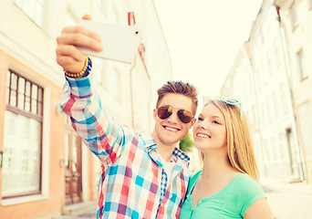 Image showing smiling couple with smartphone in city