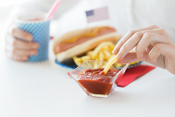 Image showing close up of woman hands eating on american food