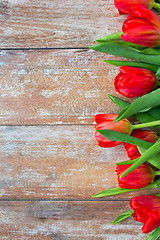 Image showing close up of red tulips on wooden background