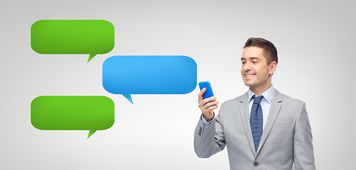 Image showing happy businessman texting message on smartphone