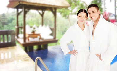 Image showing happy couple in bathrobes over spa hotel resort