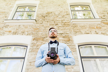 Image showing happy young hipster man with film camera in city