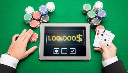 Image showing casino poker player with cards, tablet and chips