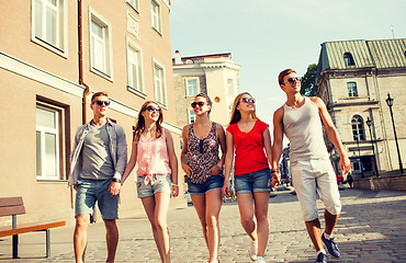 Image showing group of smiling friends walking in city