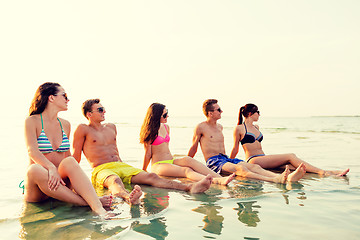 Image showing smiling friends in sunglasses on summer beach