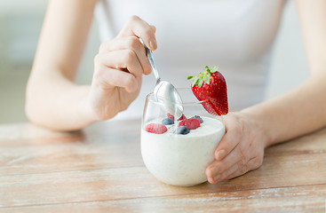 Image showing close up of woman hands with yogurt and berries