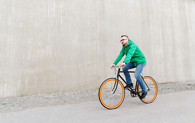 Image showing happy young hipster man riding fixed gear bike