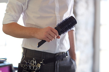 Image showing close up of male stylist with brush at salon