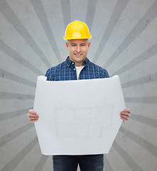 Image showing smiling male builder in helmet with blueprint