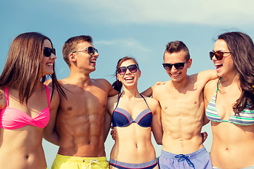 Image showing smiling friends in sunglasses on summer beach