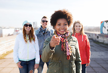 Image showing happy friends pointing finger to you on street