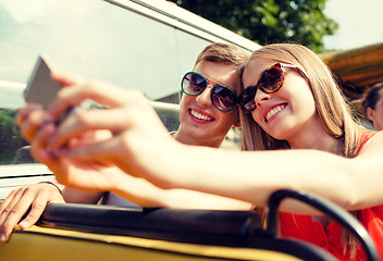 Image showing smiling couple with smartphone making selfie