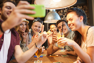 Image showing happy friends with smartphone taking selfie at bar