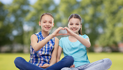 Image showing happy little girls showing heart shape hand sign