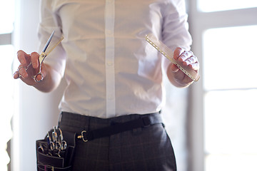 Image showing close up of male stylist with scissors at salon