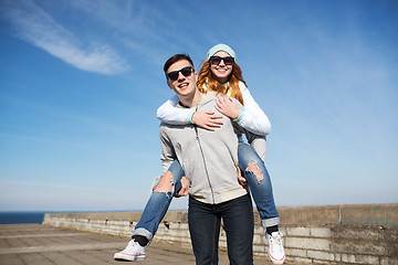 Image showing happy teenage couple in shades having fun outdoors