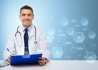 Image showing happy doctor with clipboard over blue background