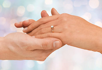 Image showing close up of man and woman hands with wedding ring